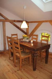 a dining room with a wooden table and chairs at Ferienwohnung Goldgrund Gartenblick in Meißen