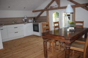 Il comprend une cuisine avec une table en bois et du parquet. dans l'établissement Ferienwohnung Goldgrund Gartenblick, à Meissen