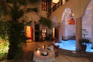 a room with tables and candles in a building at Riad Al Faras in Marrakesh