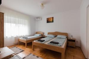 a room with two beds and a desk and a window at Airport Jazmin Guesthouse in Vecsés