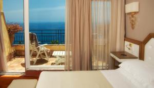 a hotel room with a bed and a balcony at Hotel Villa Belvedere in Taormina