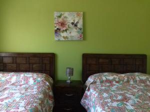 a bedroom with two beds and a picture on the wall at Estancia Buen Dia in Ciudad Valles
