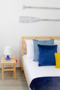 a bedroom with a bed with blue and yellow pillows at BaixaMar Apartments in Olhão