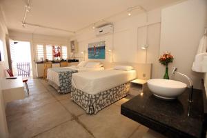 Una habitación de hotel con dos camas y un lavabo. en Saint Germain Kite Residence, en Icaraí