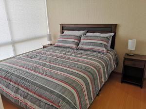 ein Bett mit gestreifter Decke in einem Schlafzimmer in der Unterkunft Lima Flats 3 in Lima + 39 Fotos