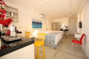a bedroom with a bed and a kitchen with a table at Saint Germain Kite Residence in Icaraí