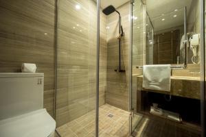 a bathroom with a shower and a toilet and a sink at Nesta Hotel Saigon in Ho Chi Minh City +95 photos