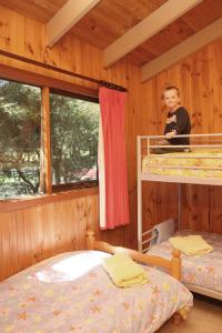 a little boy sitting on top of a bunk bed at Johanna River Farm & Cottages in Johanna