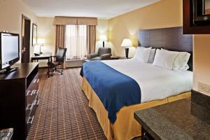 a hotel room with a large bed and a flat screen tv at Holiday Inn Express and Suites Hotel - Pauls Valley, an IHG Hotel in Pauls Valley