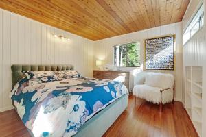 um quarto com uma cama, uma cadeira e uma janela em Tree House em Sea Ranch