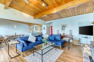 sala de estar con sofá azul y TV en Eagle's Nest Retreat, en Maple Grove Beach