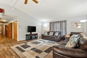 a living room with leather furniture and a flat screen tv at Coeur d'Alene Cozy in Coeur d'Alene