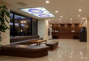 a lobby with a waiting room with a stained glass ceiling at Center Hotel Narita1 in Narita