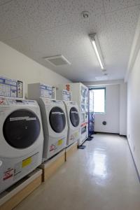 a laundry room with three washing machines on display at Center Hotel Narita1 in Narita