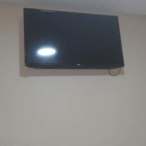 uma televisão de ecrã plano pendurada numa parede em Royal Hotel em São Paulo