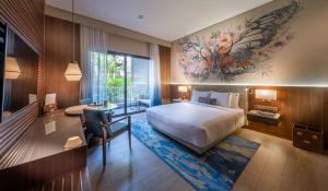 a hotel room with a bed and a desk and a desk at Hard Rock Hotel Desaru Coast in Desaru