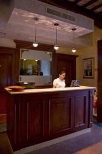 a woman standing at a kitchen counter with a mirror at Relais Villa Fornari in Camerino