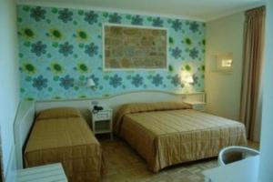 Relais Villa Fornari في كاميرينو: غرفة نوم بسريرين وجدار بالورود