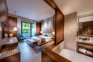 a bedroom with a king sized bed and a bathroom at Hard Rock Hotel Desaru Coast in Desaru
