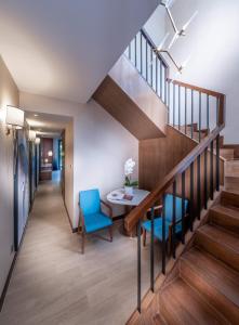 a hallway with stairs and a table and blue chairs at Hard Rock Hotel Desaru Coast in Desaru