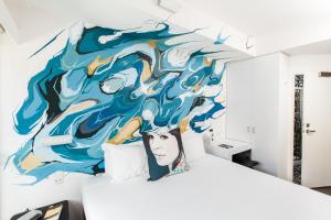 a bedroom with a mural on the wall at Majestic Minima Hotel in Adelaide