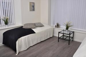 a white bedroom with a bed and a table at AB Centrum Aarhus Bed without Breakfast in Aarhus