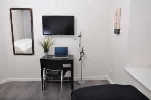 a room with a desk with a laptop and a mirror at AB Centrum Aarhus Bed without Breakfast in Aarhus