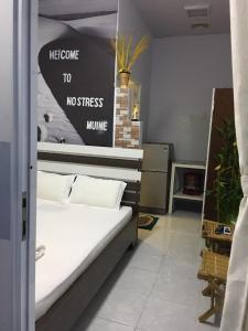 a bedroom with a bed with a sign that reads welcome to no stress mummy at Nostress Guest House in Mui Ne