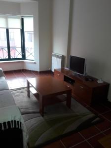 un soggiorno con tavolino e TV di Estrela do Mar - 100m da praia a Peniche