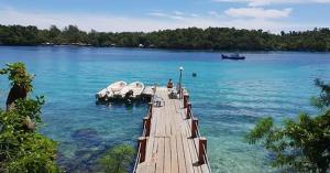 przystań nad jeziorem z łodzią w wodzie w obiekcie Olala Café & Bungalows w mieście Sabang