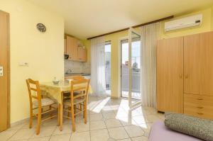 a kitchen and dining room with a table and chairs at Apartment and Room Ilija in Tribunj