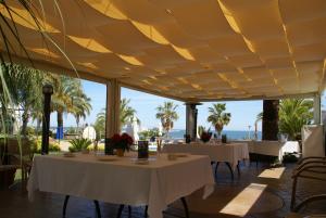 a restaurant with white tables and a view of the ocean at Miami Mar - Boutique Hotel & Restaurante in Sant Carles de la Ràpita +48 photos