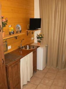 een keuken met een wastafel en een televisie in een kamer bij Cantuccio in Cengio