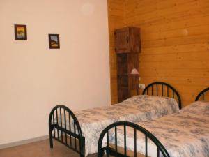 three beds in a room with wooden walls at Cantuccio in Cengio