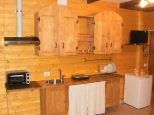 uma cozinha com armários de madeira e um lavatório em Cantuccio em Cengio
