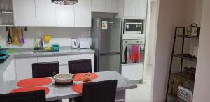 una cocina con mesa y una cocina con refrigerador en Departamentos La Serena Vista, en La Serena