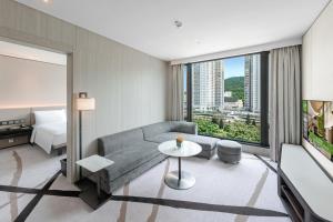 a living room filled with furniture and a large window at ALVA HOTEL BY ROYAL in Hong Kong