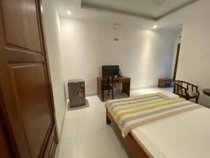 a small bedroom with a bed and a desk at HOTEL AN HOÀ II in Ba Ria +28 photos