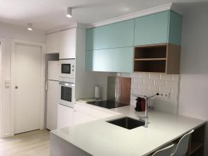 a kitchen with white cabinets and a counter top at Frente al Mar. Atlantic in Denia