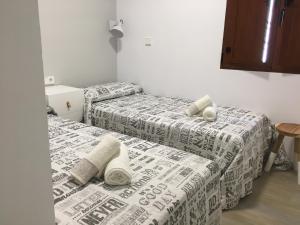 2 Betten in einem Zimmer mit Handtüchern darauf in der Unterkunft Frente al Mar. Atlantic in Denia