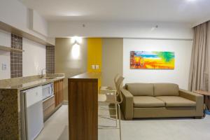 a living room with a couch and a kitchen at OPR - Resort em Olimpia Frente Piscina in Olímpia