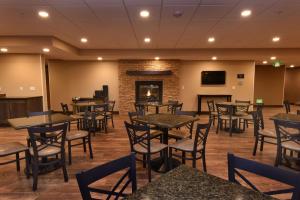 a restaurant with tables and chairs and a fireplace at Best Western Plus Vintage Valley Inn in Zillah