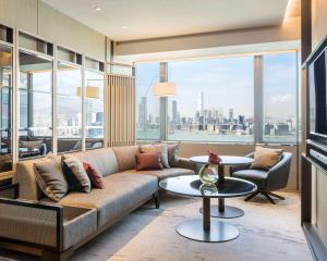 a living room with a couch and a view of the city at Hyatt Centric Victoria Harbour in Hong Kong