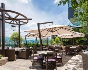 a patio with tables and chairs with umbrellas at Hyatt Centric Victoria Harbour in Hong Kong