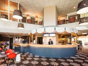 a lobby of a restaurant with a bar and chairs at ibis Château-Thierry in Essômes-sur-Marne