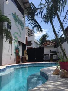 a swimming pool with palm trees next to a building at Casa Areka in Panama City