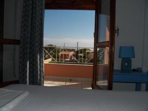 a bedroom with a bed and a view of a balcony at Villa Marina in Ipsos
