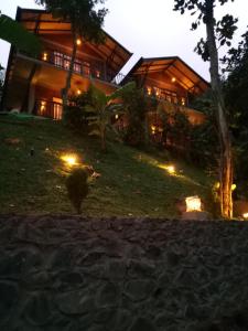 uma casa com luzes à frente à noite em 3Arch Eco Cottage Ella em Ella