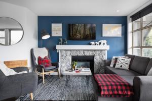 a living room with blue walls and a fireplace at THE LOOKOUT PENTHOUSE // a luxe suite in Whistler in Whistler