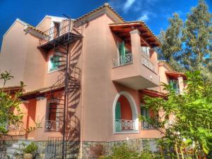 a peach colored building with balconies and trees at Villa Marina in Ipsos